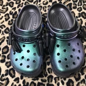 NWOT. Women’s Crocs iridescent green/black tassels
